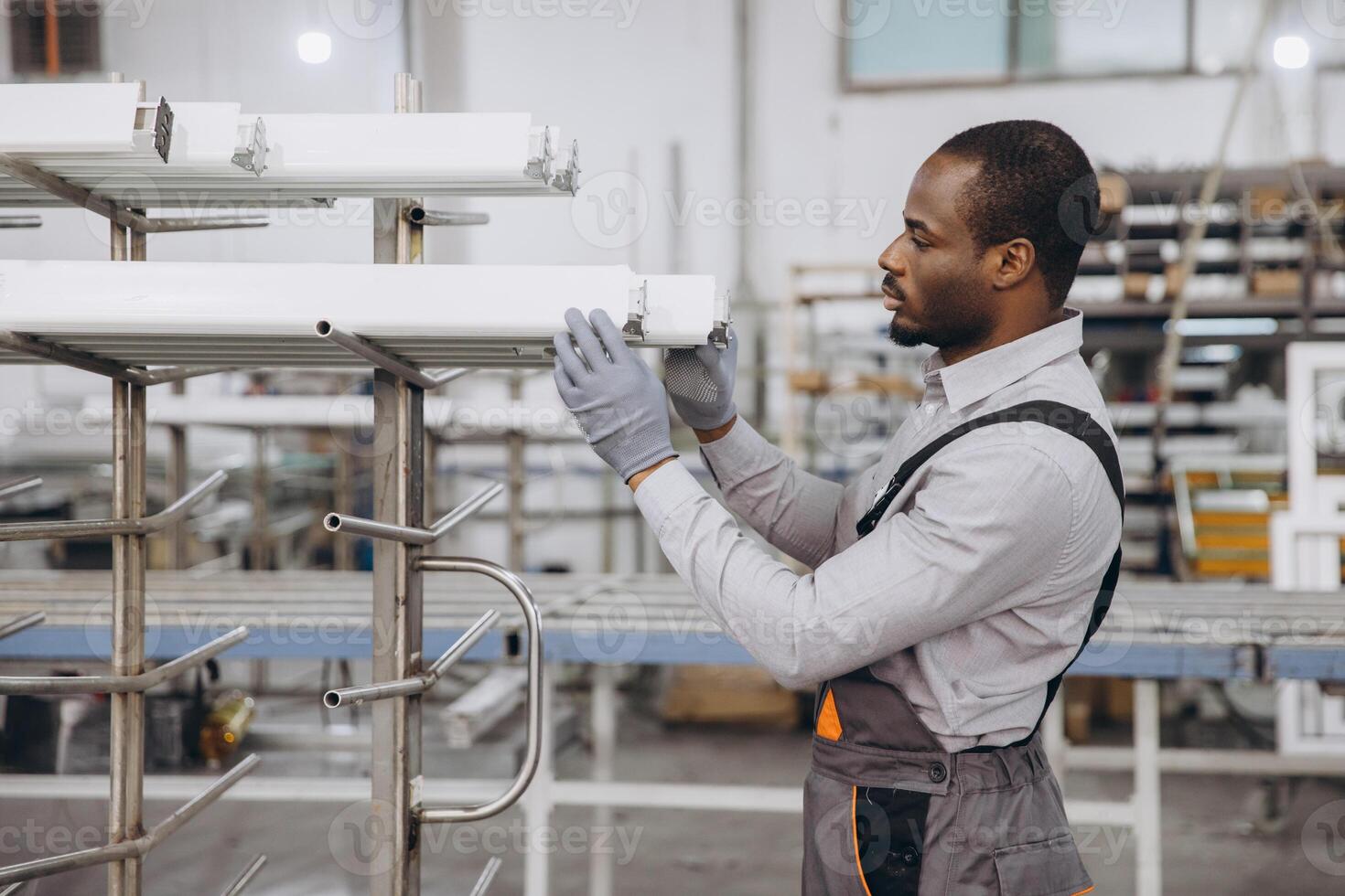 Factory worker checking aluminum window frames in production line photo