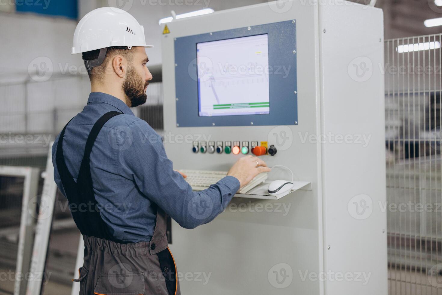 Factory worker operating industrial machinery for aluminum and PVC windows and doors production photo