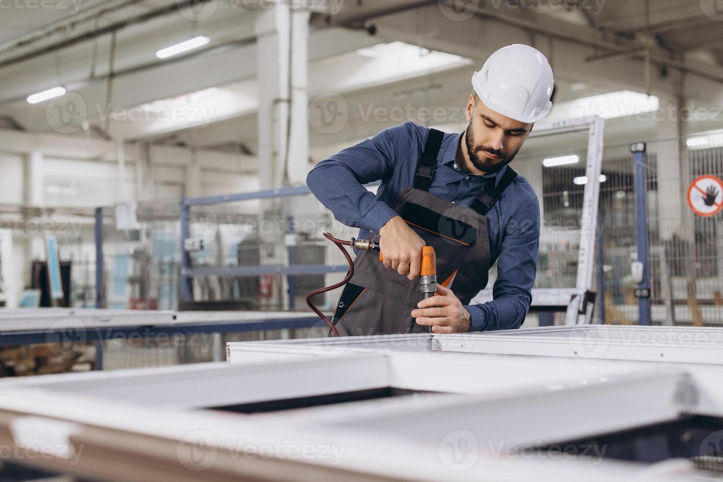 Factory worker assembling aluminum window frames in production line photo