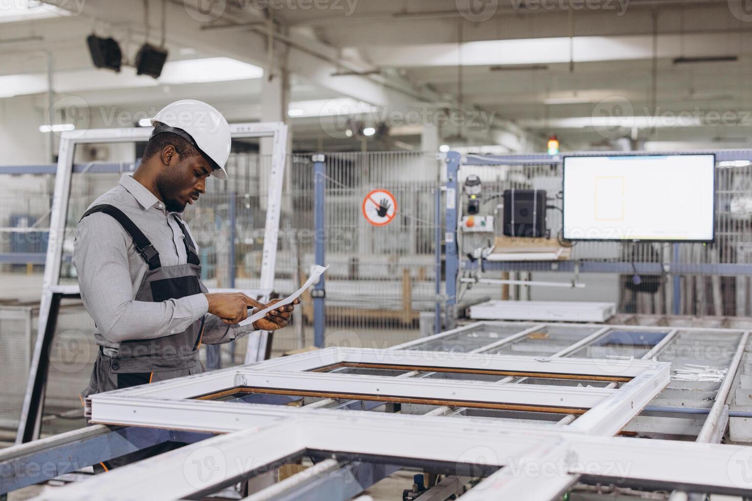 Engineer inspecting PVC window frame in factory photo