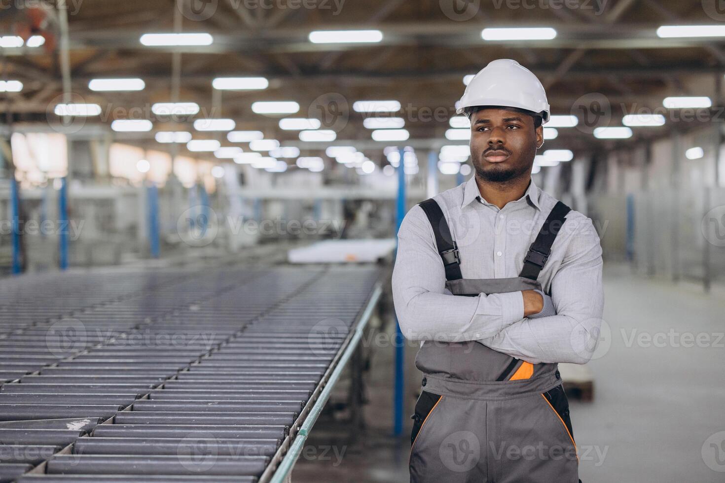 Supervisor posing with arms crossed in window factory photo