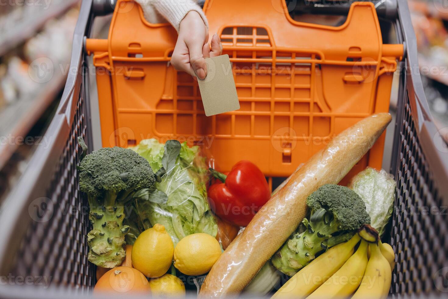 Customer paying with credit card for groceries in supermarket cart photo