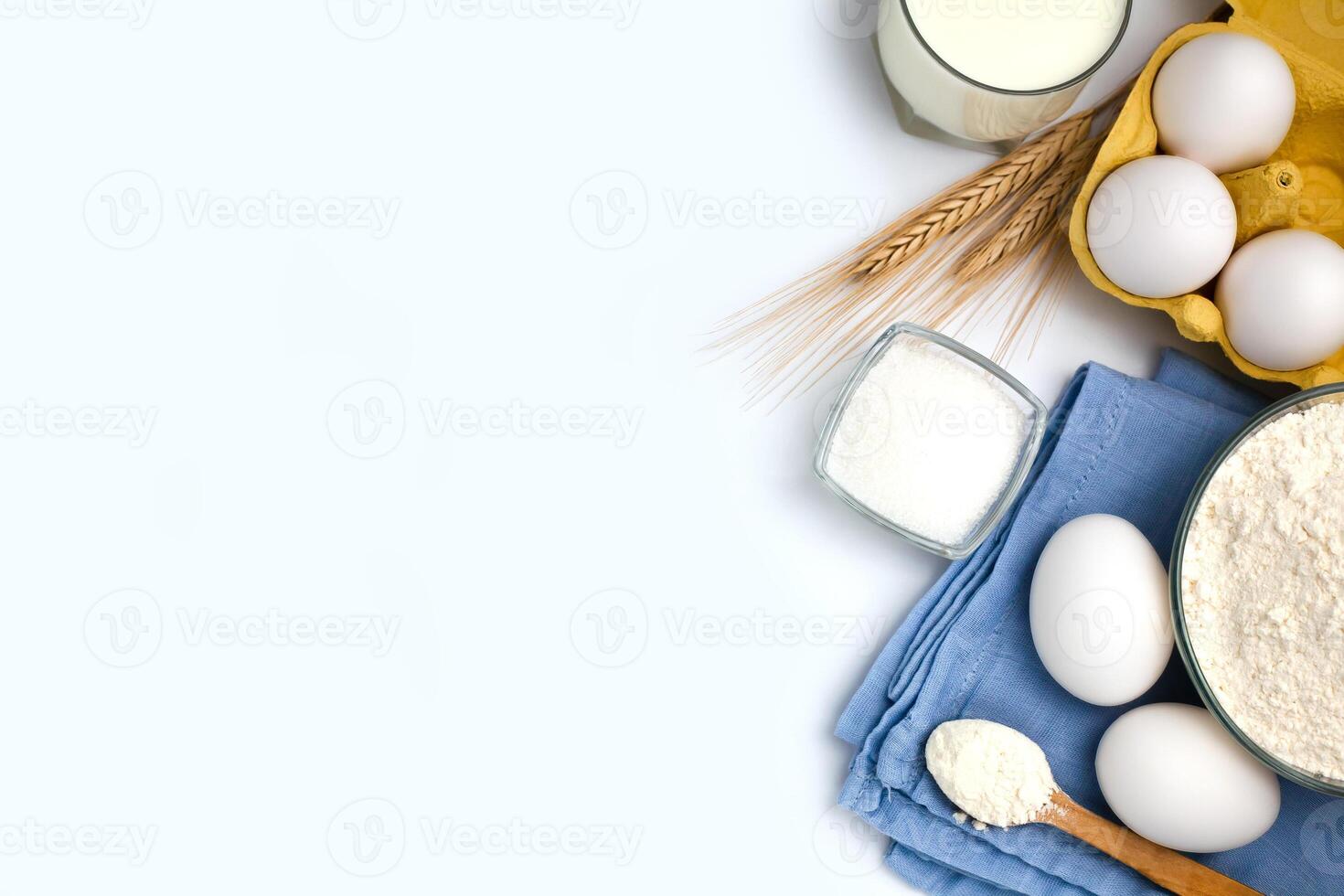 Ingredients for dough preparation flour, eggs, milk and sugar on white background. Flatlyy composition. Close-up. Top view. Copy space. photo