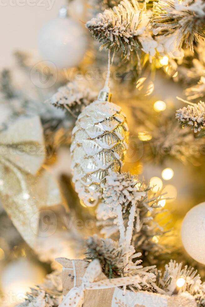 Snow-covered Christmas tree with white pinecone Christmas decorations close-up with warm lights. Decorations for the New Year and Christmas photo