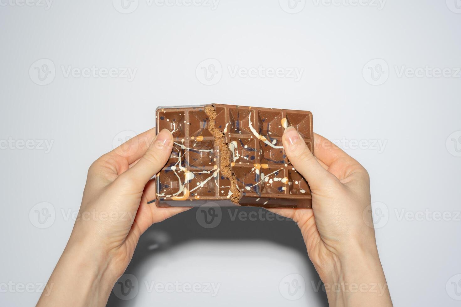 Trend Dubai chocolate with chocolate spread and kataifi broken in woman's hands. Confectionery handmade sweets, chocolatier. photo