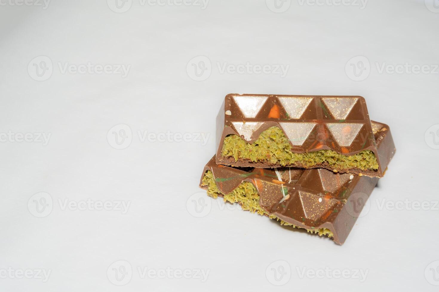 Trend Dubai chocolate bar with pistachio paste, tahini and kataifi dough on white background. Confectionery and sweets. photo