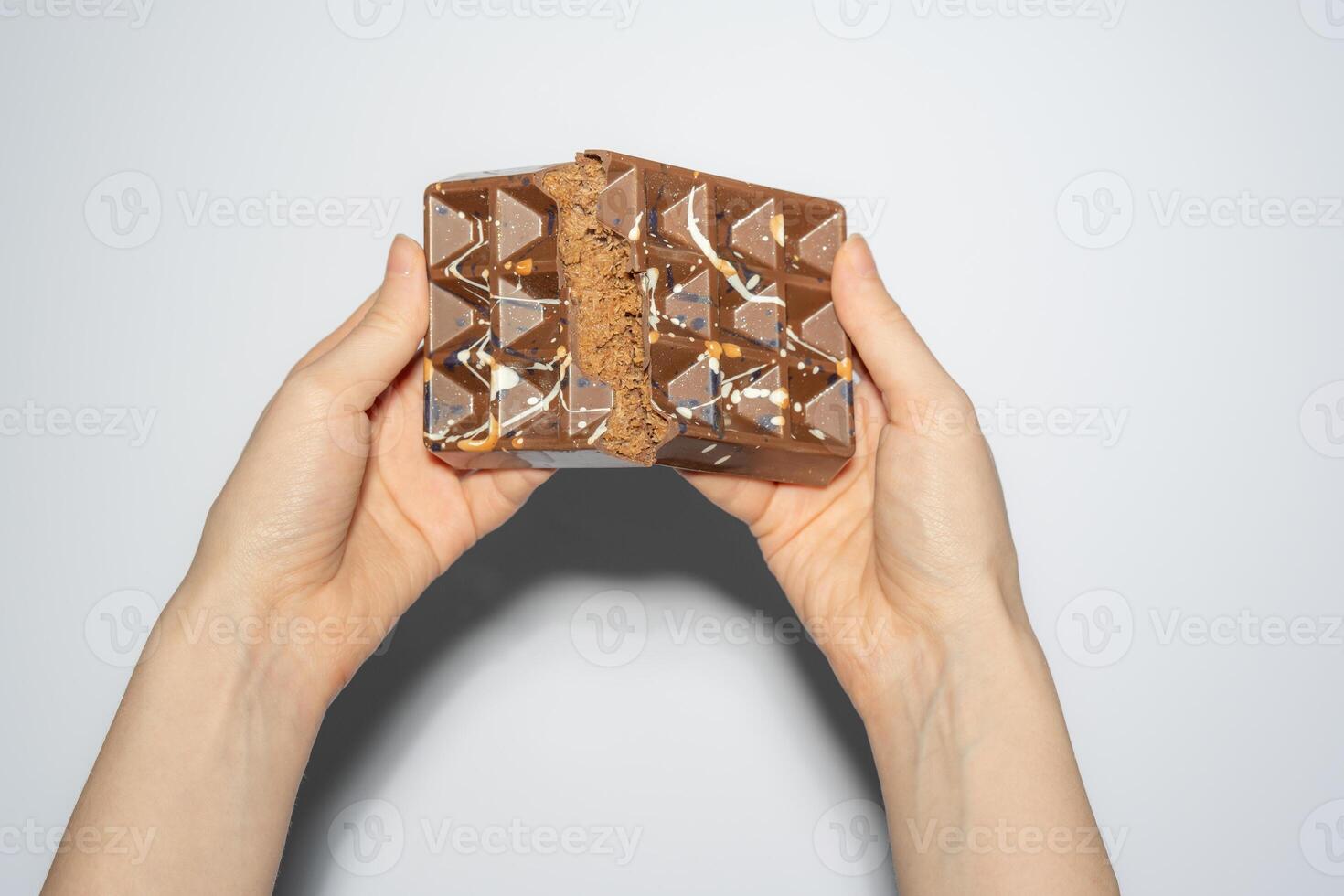 Famous Dubai chocolate with chocolate spread and kadaif broken in woman's hands. Confectionery handmade sweets, chocolatier photo