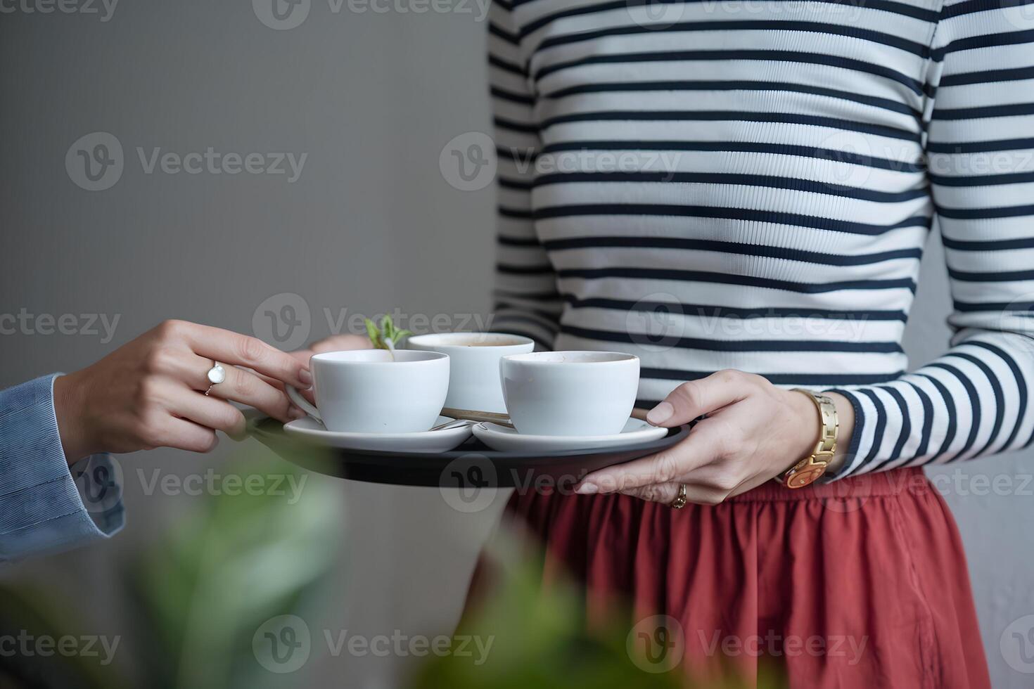 Woman with tray of white cups in calm indoor greenery infused setting photo