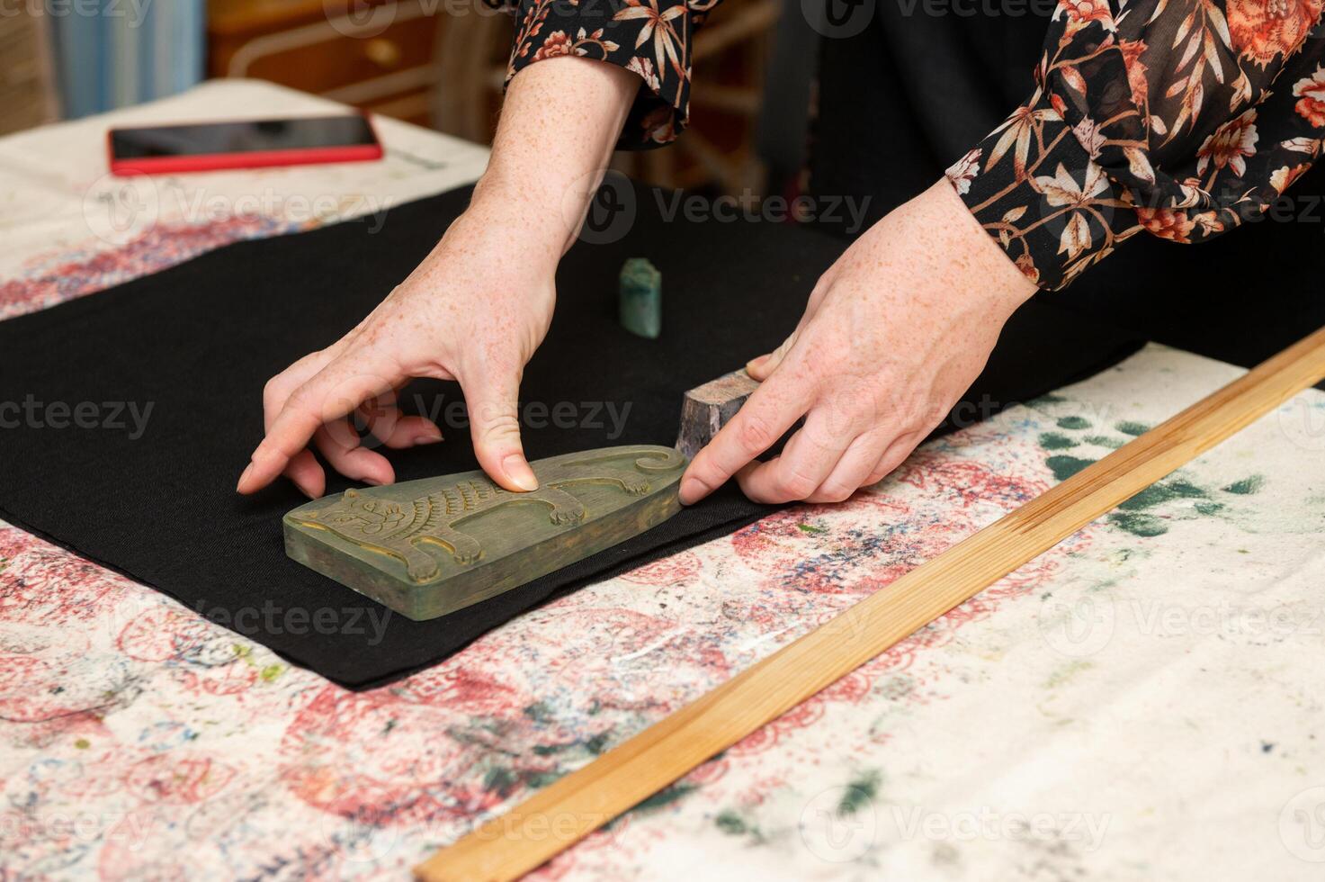 Young caucasian female engraving wood with patterns on fabric table photo