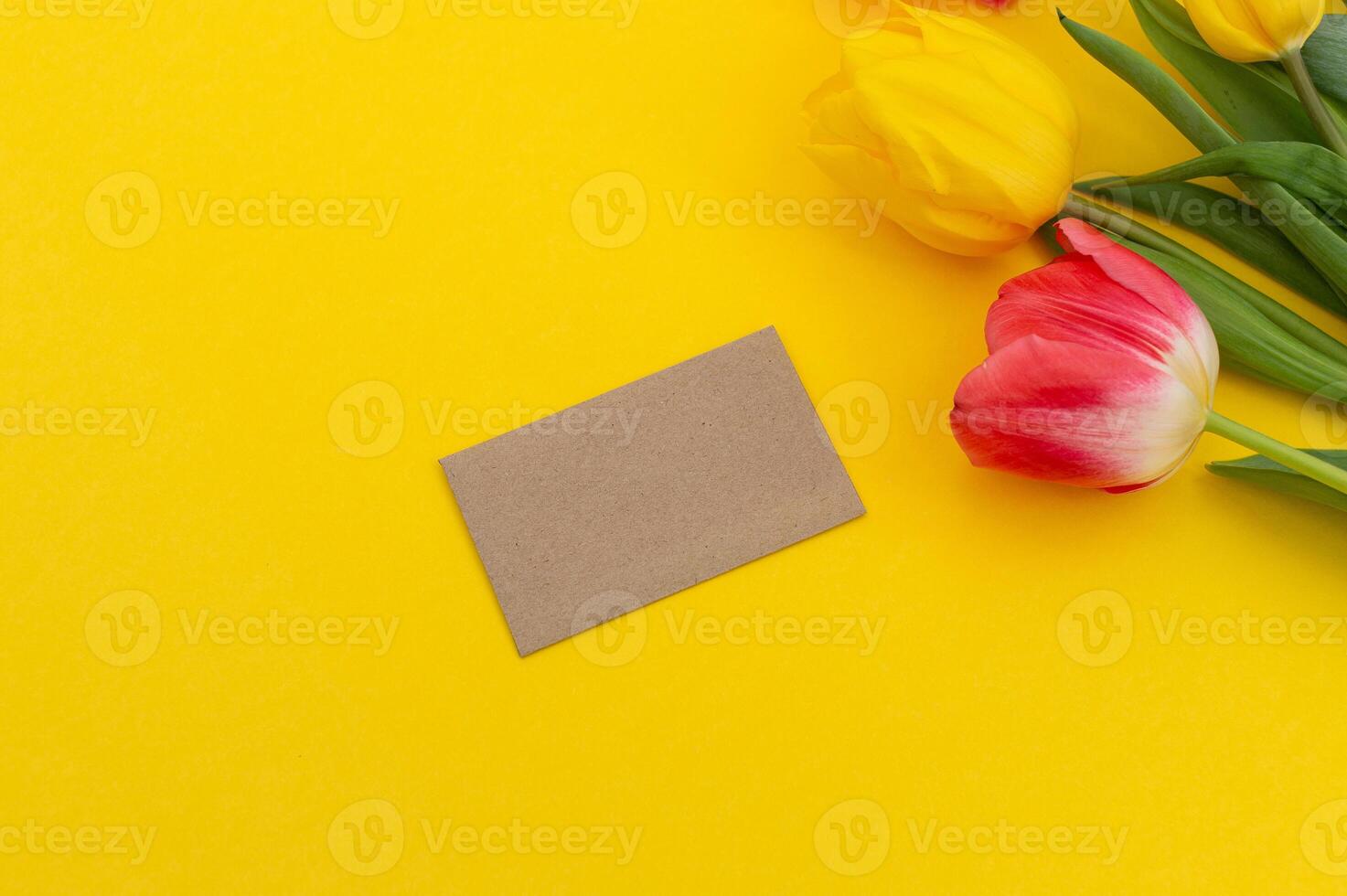 Spring Tulips with Blank Card on Yellow Background photo