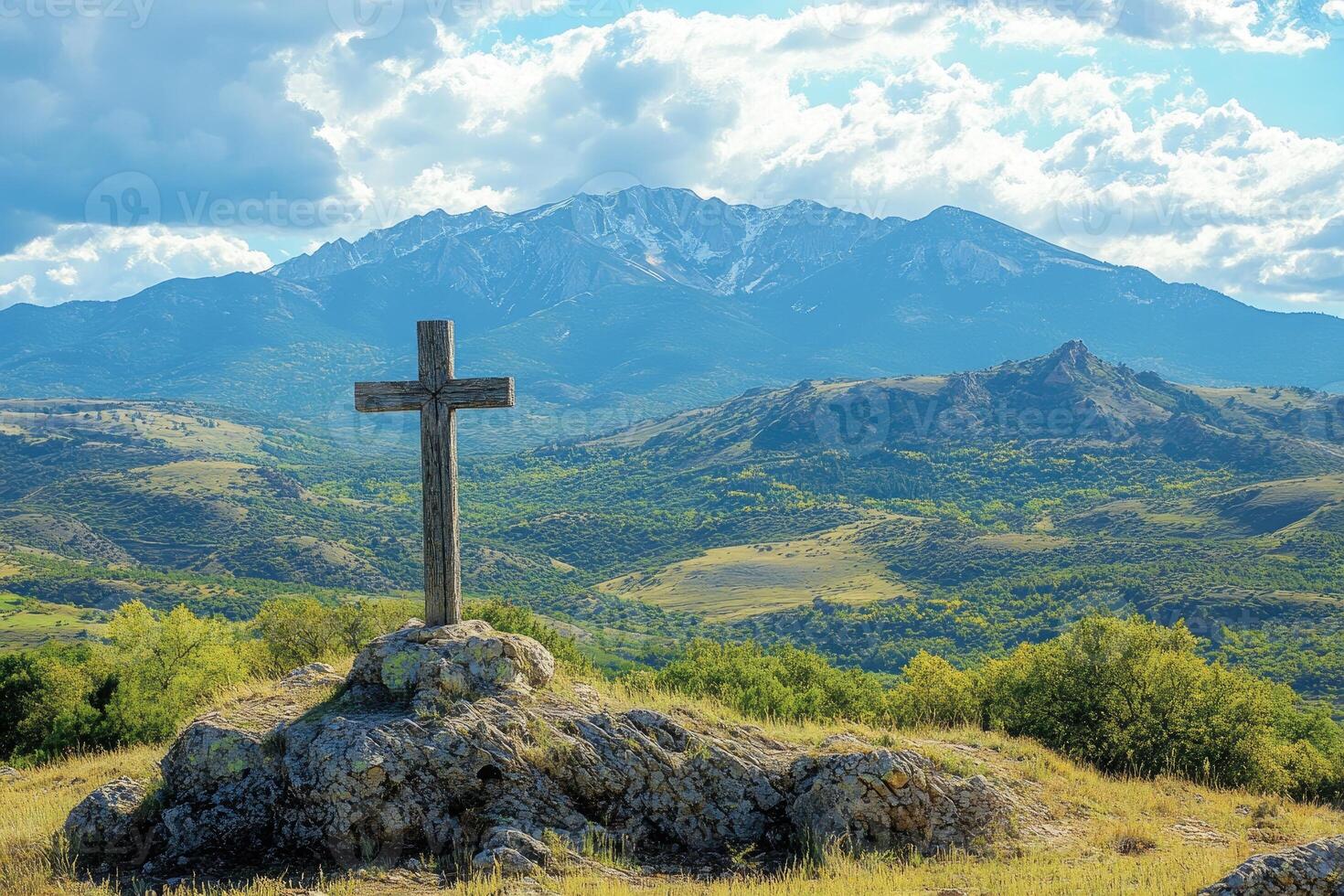 Wooden cross standing on a rock overlooking majestic mountains photo