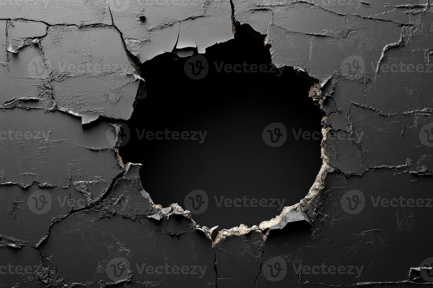 Cracks forming large hole on dark gray wall creating deep void photo