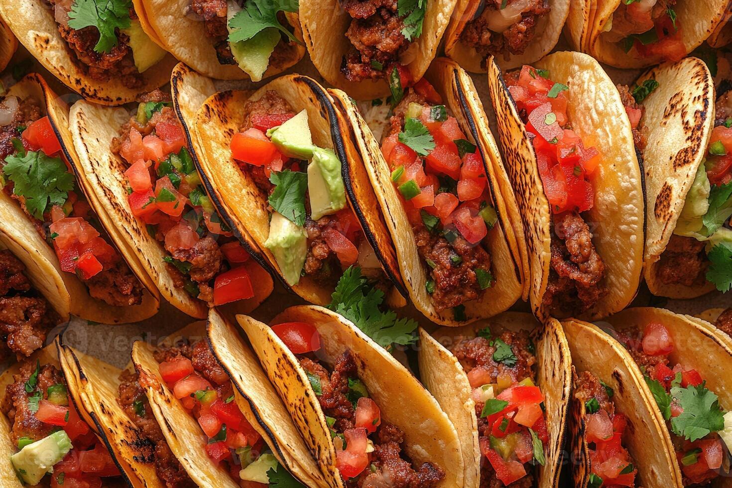 Delicious crunchy tacos with cilantro, tomatoes, onions, and avocado filling a table photo