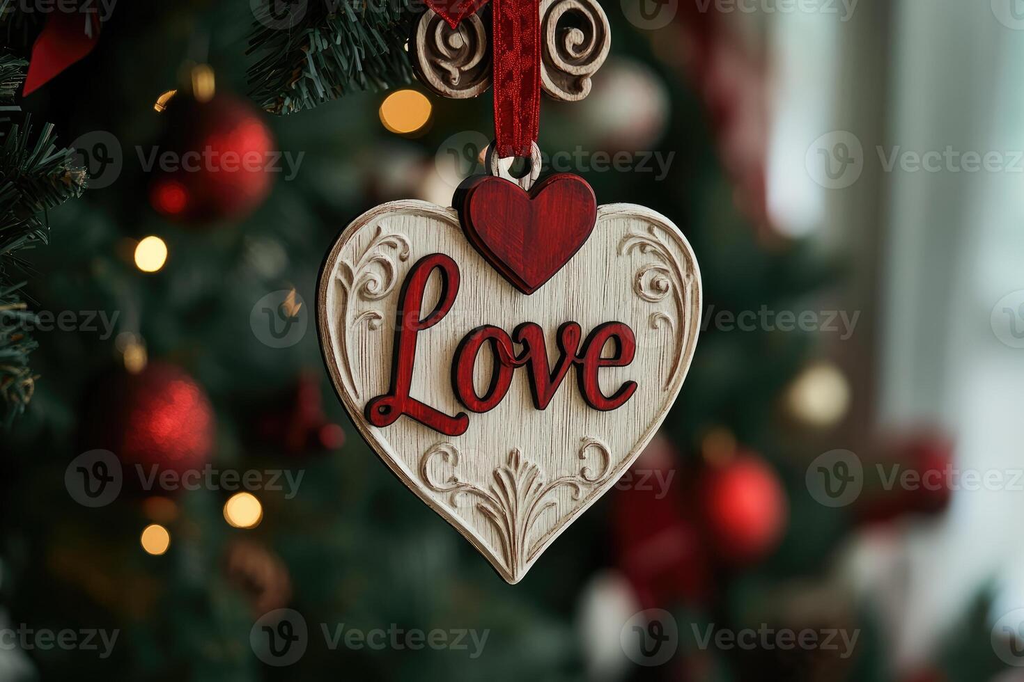 Heart-shaped christmas ornament expressing love hanging on a snowy christmas tree photo