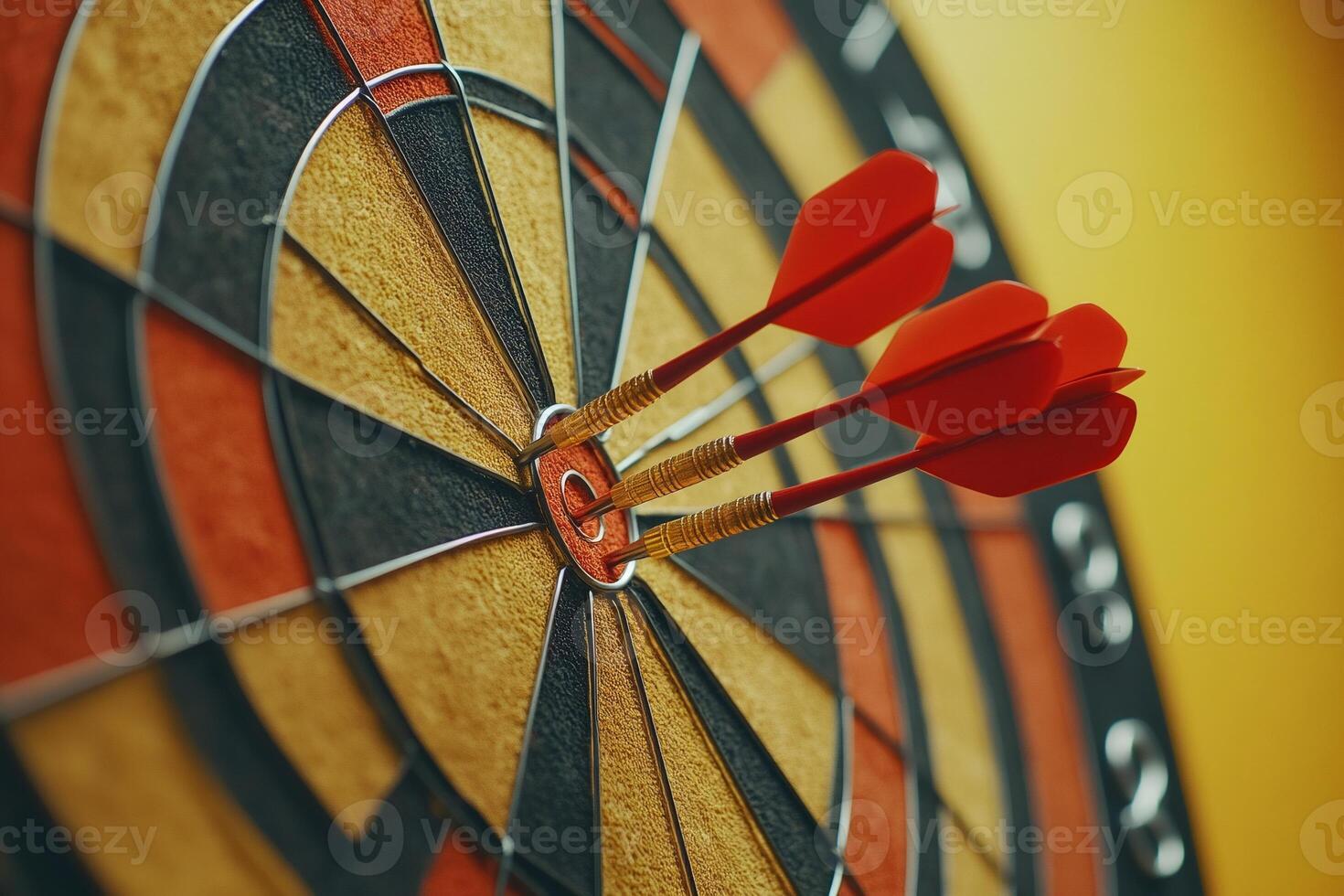 Three red darts hitting the bullseye of dartboard target on yellow background photo