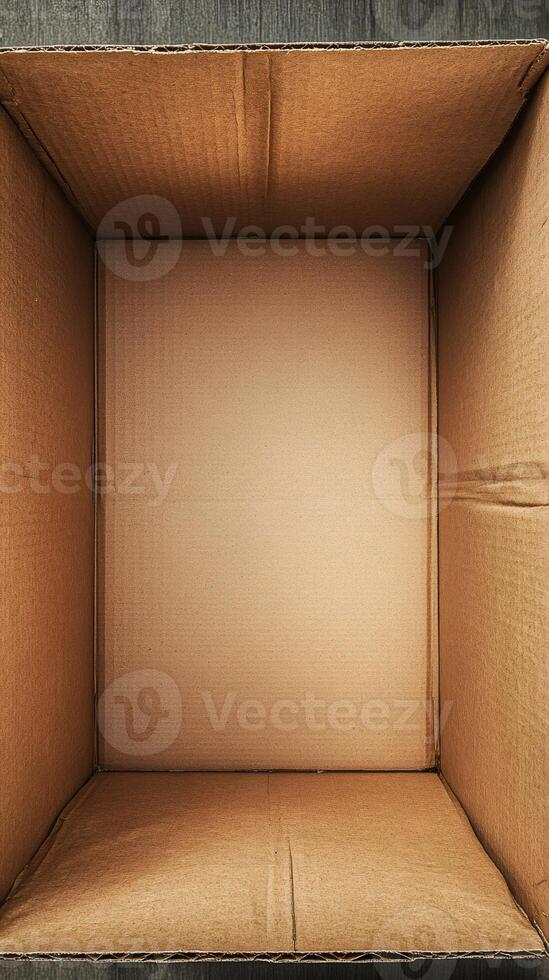 Open empty cardboard box on wood table, ready for shipping photo