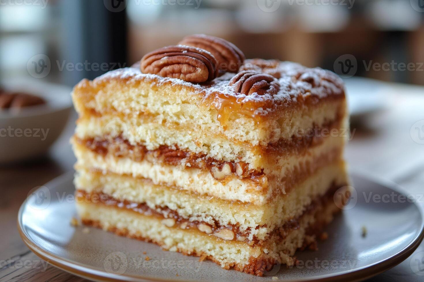 Delicious layered cake with pecan nuts and caramel filling on a plate photo