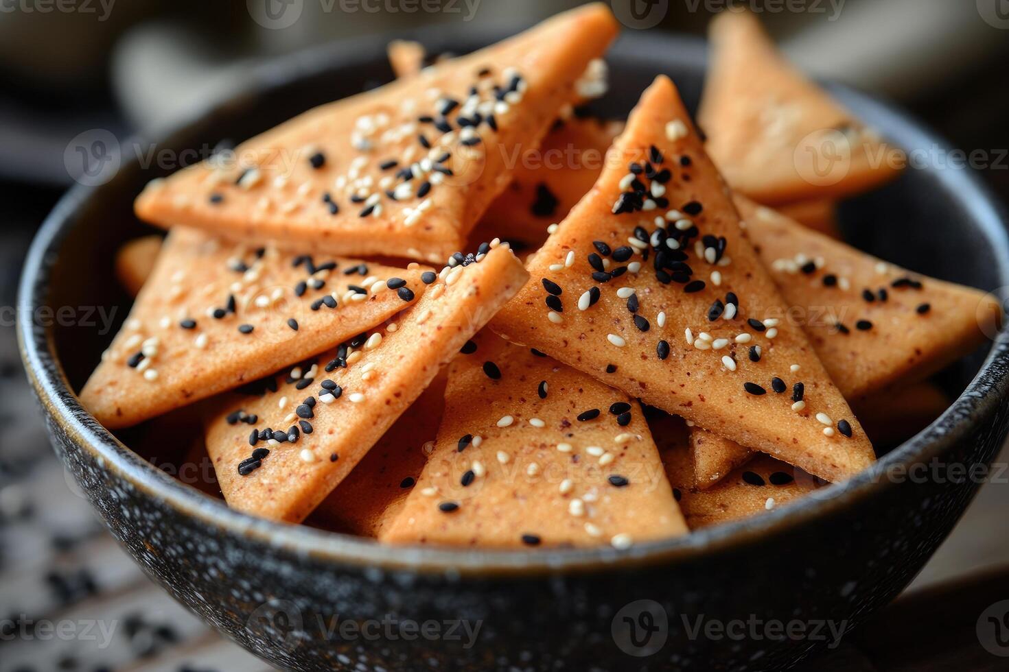 Delicious homemade sesame crackers sprinkled with black and white seeds in a bowl photo