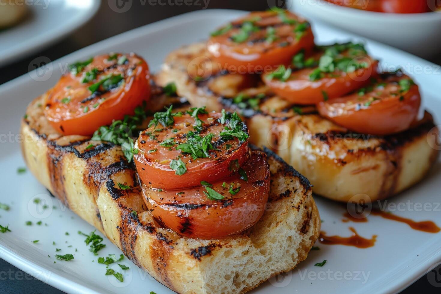 Grilled bruschetta with tomatoes and herbs resting on white plate photo
