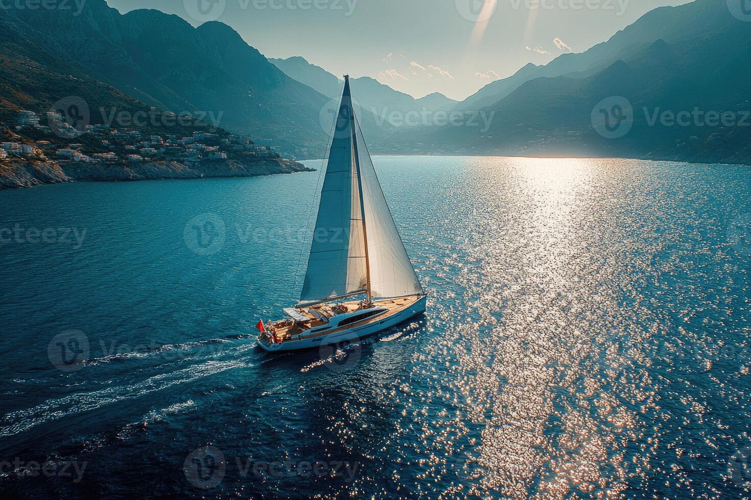 Sailing boat navigating on deep blue ocean under cloudy sky with sun reflections photo