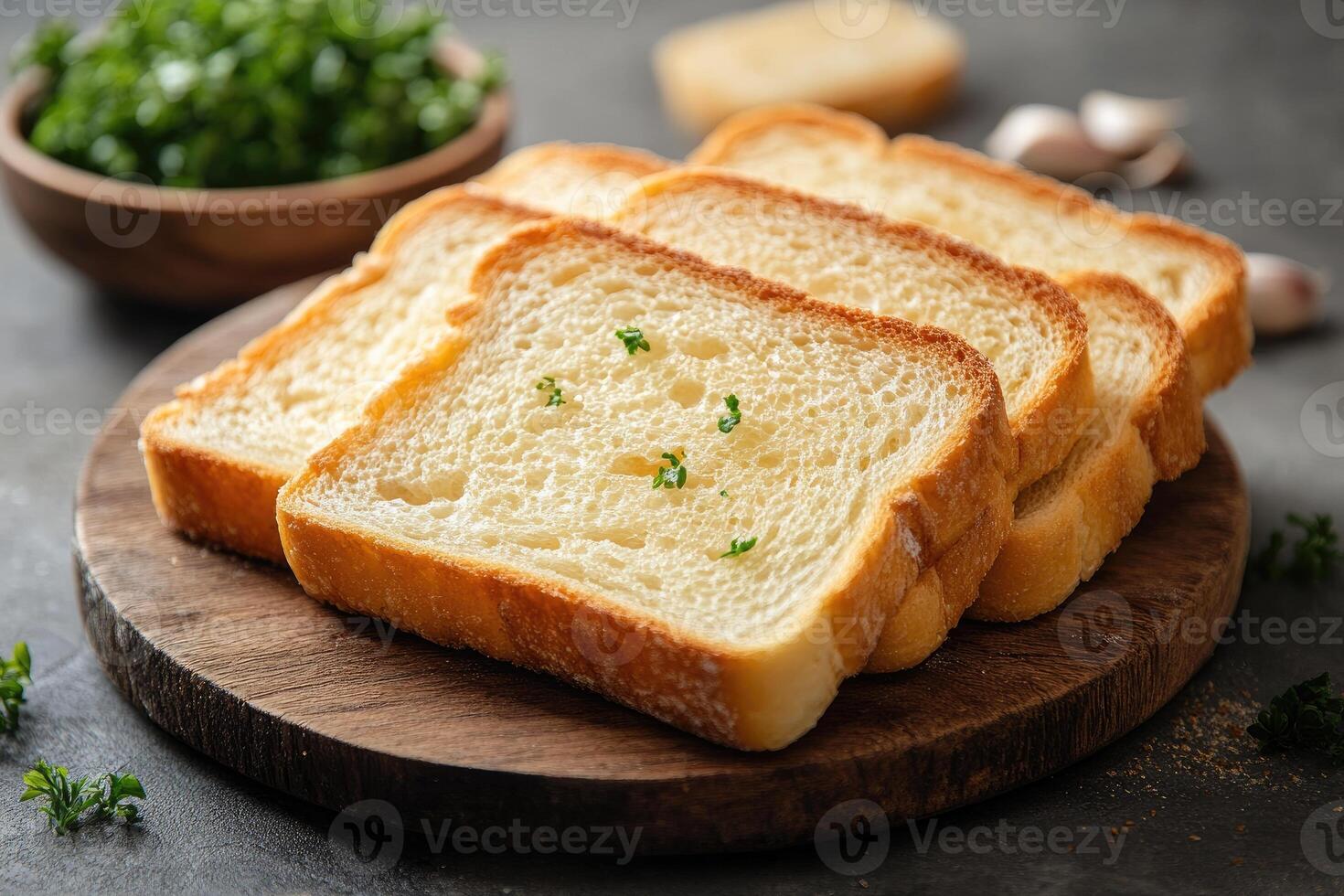 Toasted slices of bread with garlic and parsley on wooden board photo