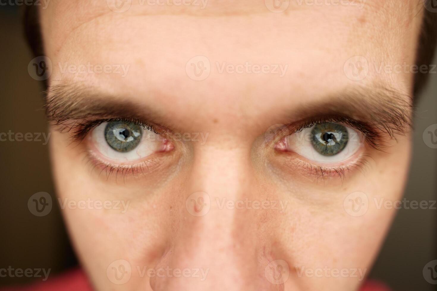 Intense gaze with gray eyes. Male face with focused expression. photo