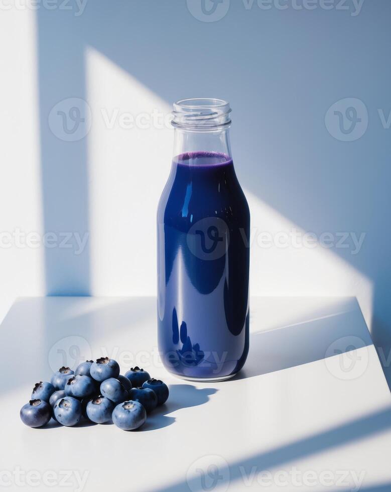 Blueberry juice in a glass bottle on a table photo