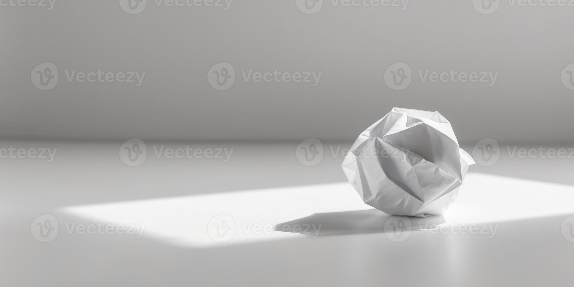A crumpled paper ball on a white surface photo