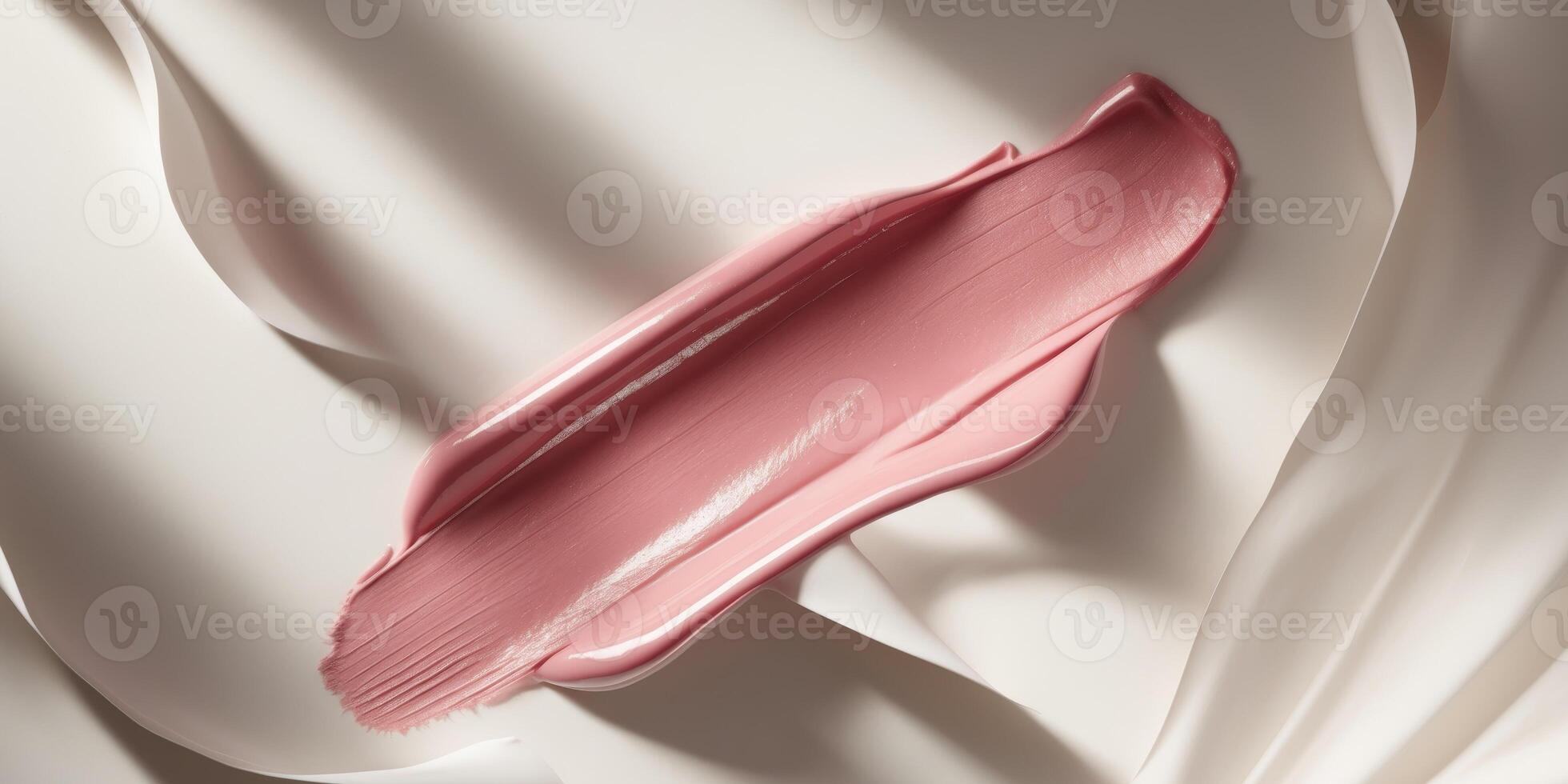 A pink lipstick is laying on a white surface photo