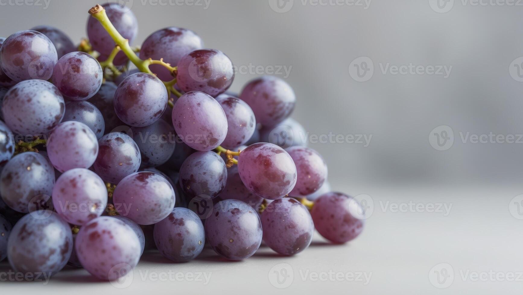 A bunch of purple grapes are piled on top of each other. photo