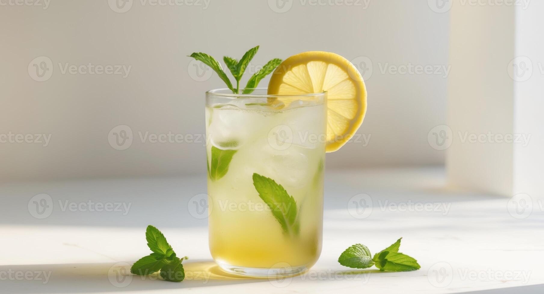 A glass of lemonade with mint leaves on the side photo