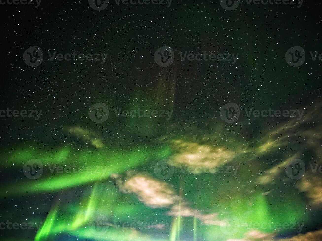 Conceptual shot of stars with aurora and clouds, rotating around the north photo