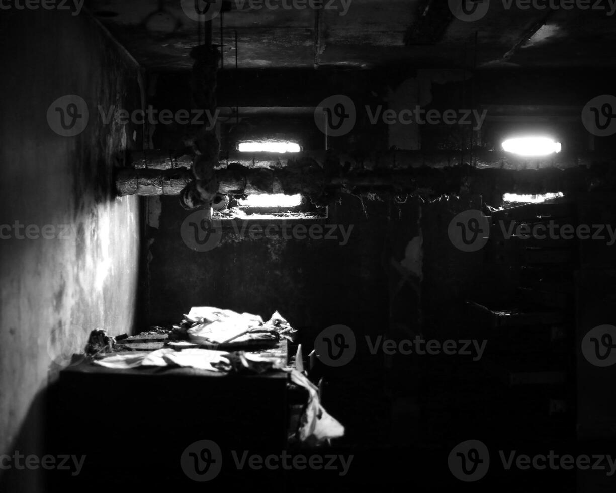 Black and white shot of desolate workplace in the basement with lots of paperwork photo
