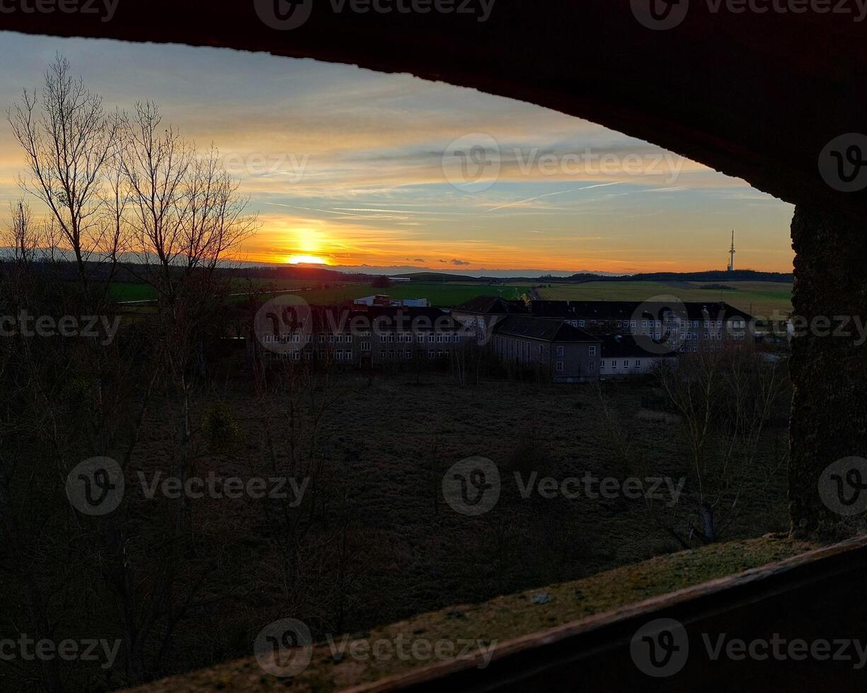 View from old window over a rural landscape in sunset photo