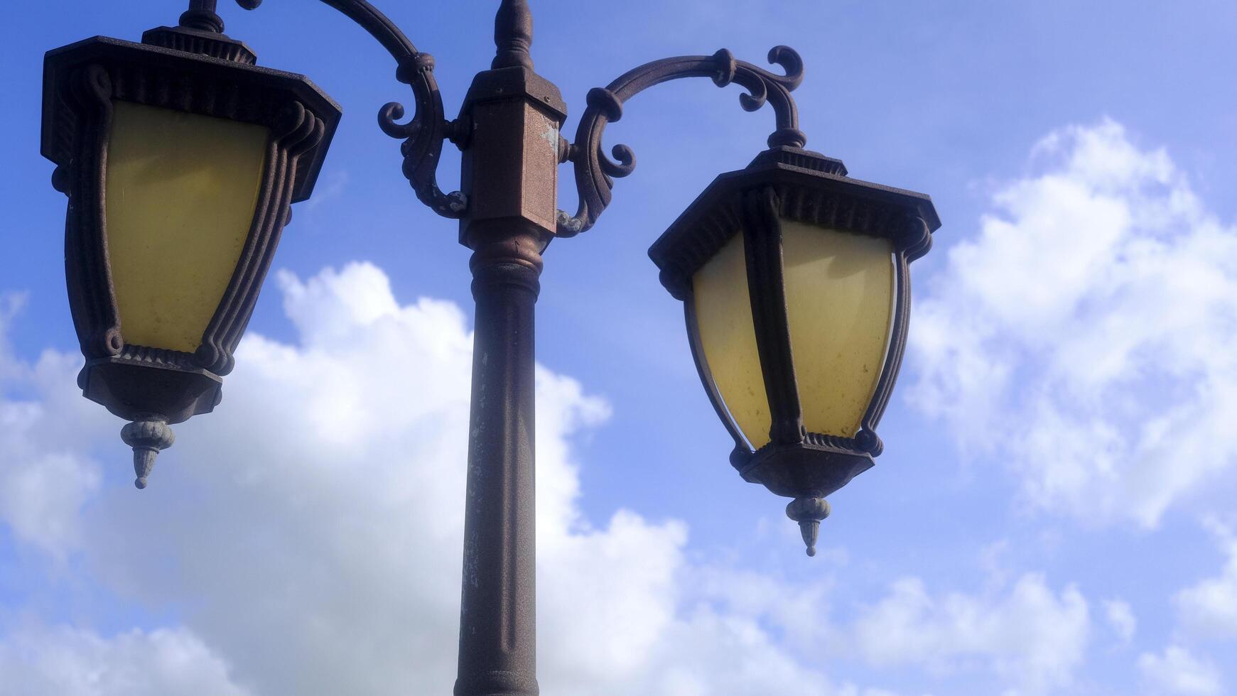 Retro style street lamp, blue sky and white clouds photo