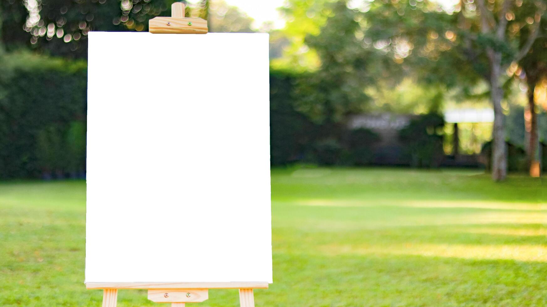 White board sign for writing text on blurred lush green trees background photo