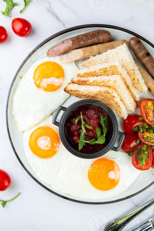 Breakfast of eggs and vegetables with cherry tomatoes and slices of bread top view photo