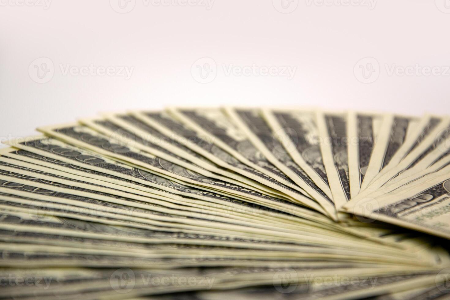 A close-up view of a fan of US dollar bills arranged on a white surface photo