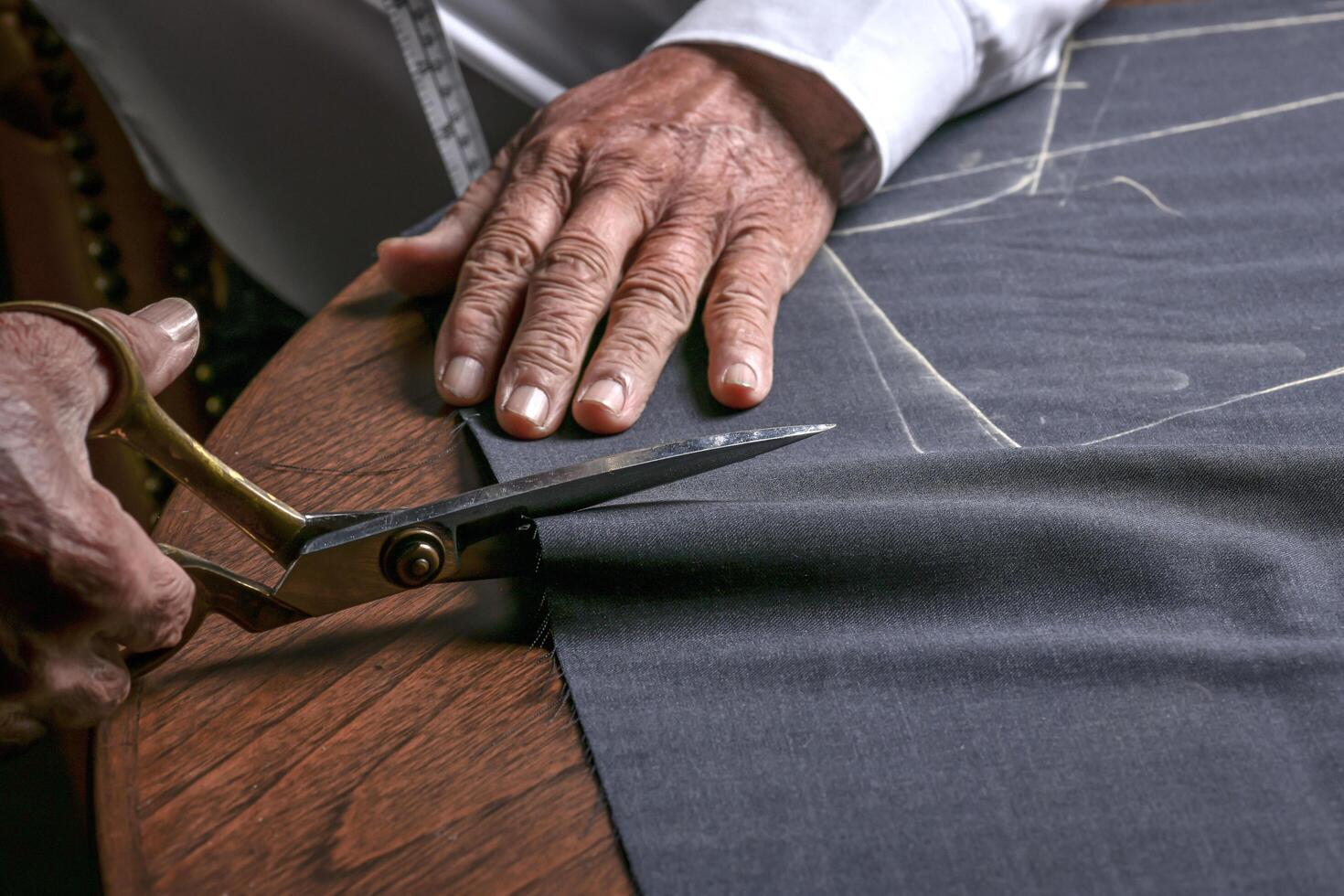 A tailor cutting a cloth according to the tradition of tailors. The dressmaker uses perfectly needle and thread to sew traditional concept, sewing photo