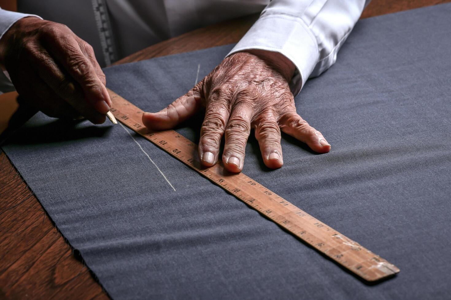 A tailor cutting a cloth according to the tradition of tailors. The dressmaker uses perfectly needle and thread to sew traditional concept, sewing photo