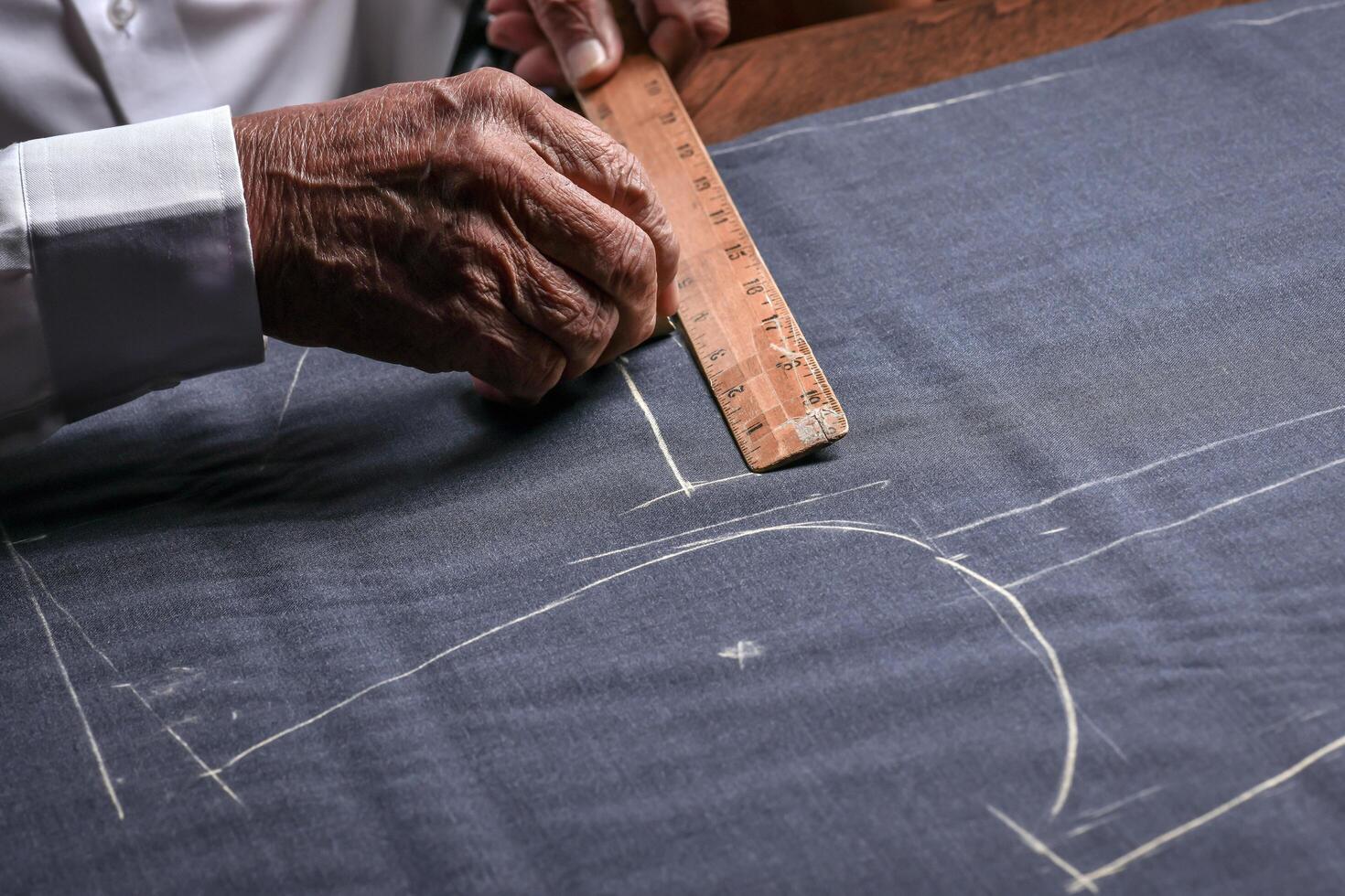 A tailor cutting a cloth according to the tradition of tailors. The dressmaker uses perfectly needle and thread to sew traditional concept, sewing photo