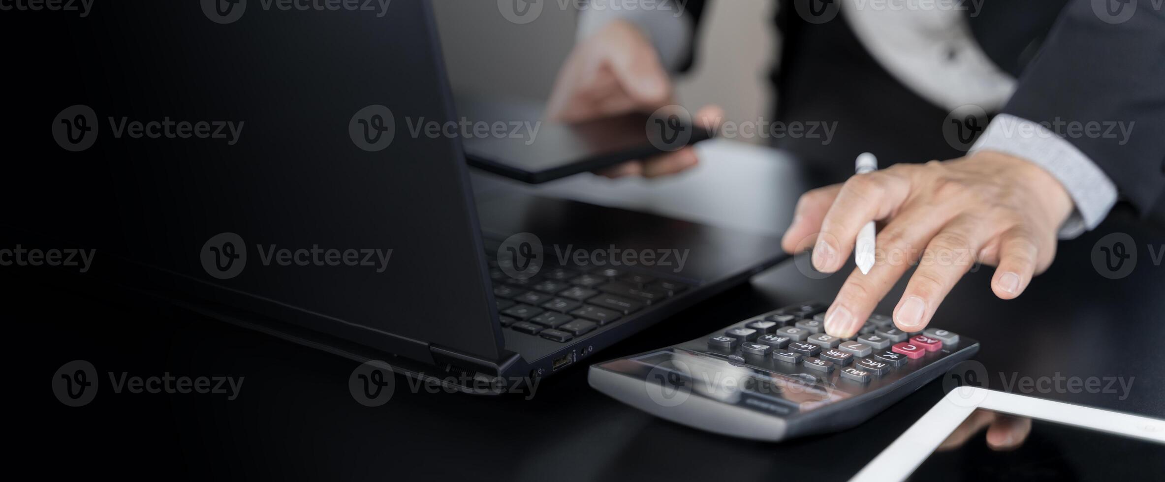 Business accounting concept, Business man using calculator with computer laptop, budget and loan paper in office. photo