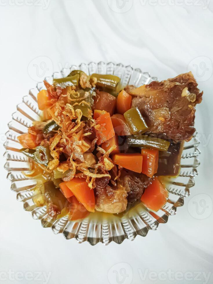 Asem-asem Daging or Vegetable Sour Beef Soup is typical dish of Java, Indonesia. With beef, carrot and beans as ingredients plus Javanesse starfruit. photo