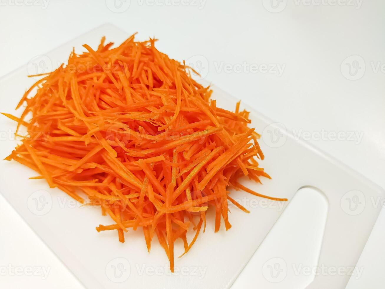 View of juice sliced carrots. Julienne carrot in a white plate. Copy space. photo