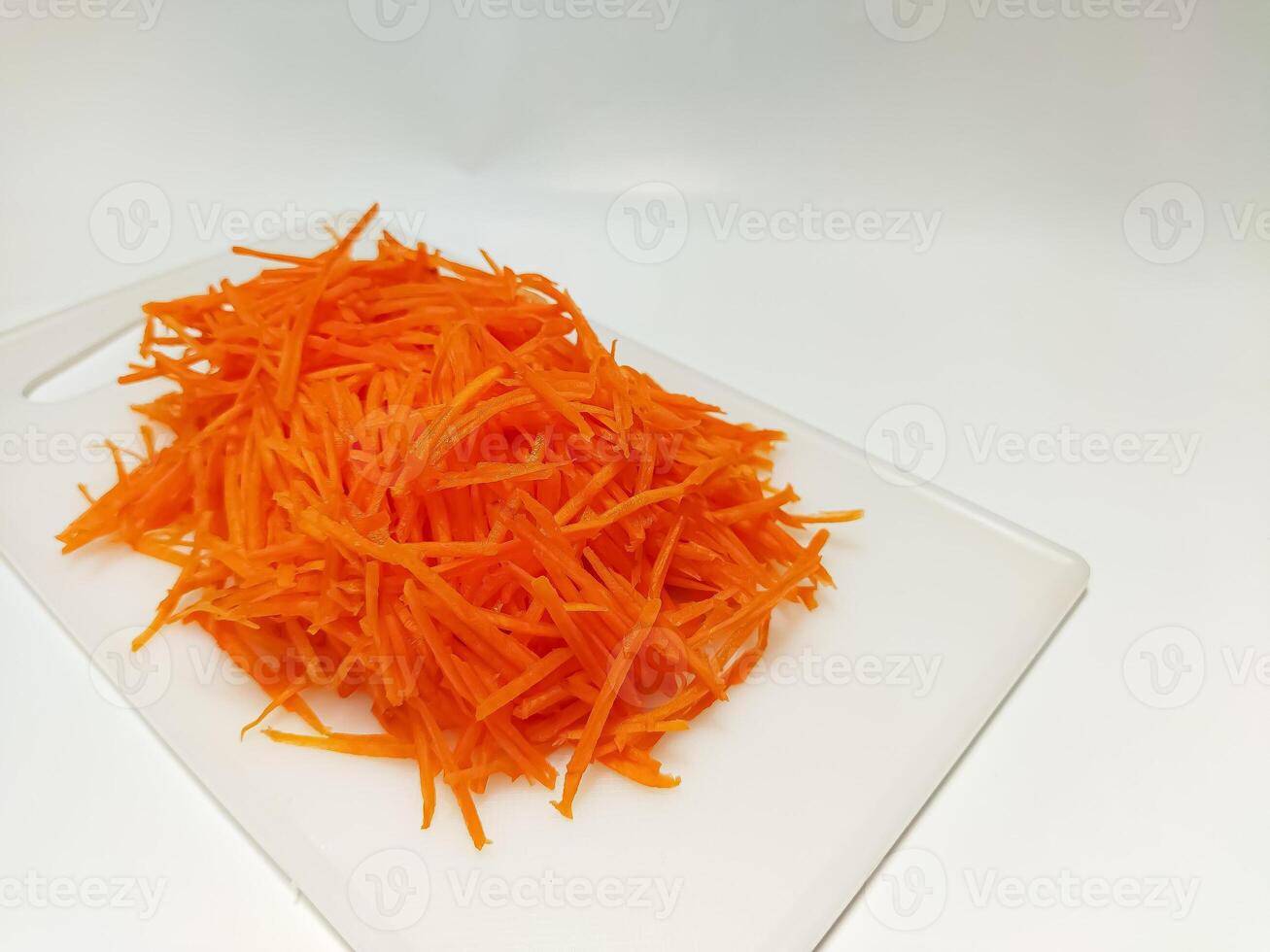View of juice sliced carrots. Julienne carrot in a white plate. Copy space. photo