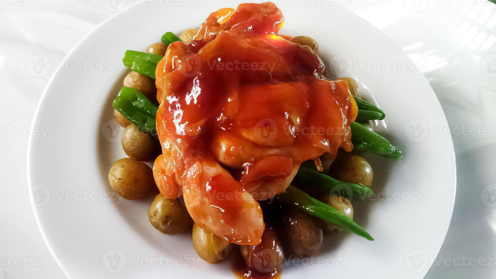 Chicken steak with delicious barbeque sauce served with baby potatoes and chickpeas photo