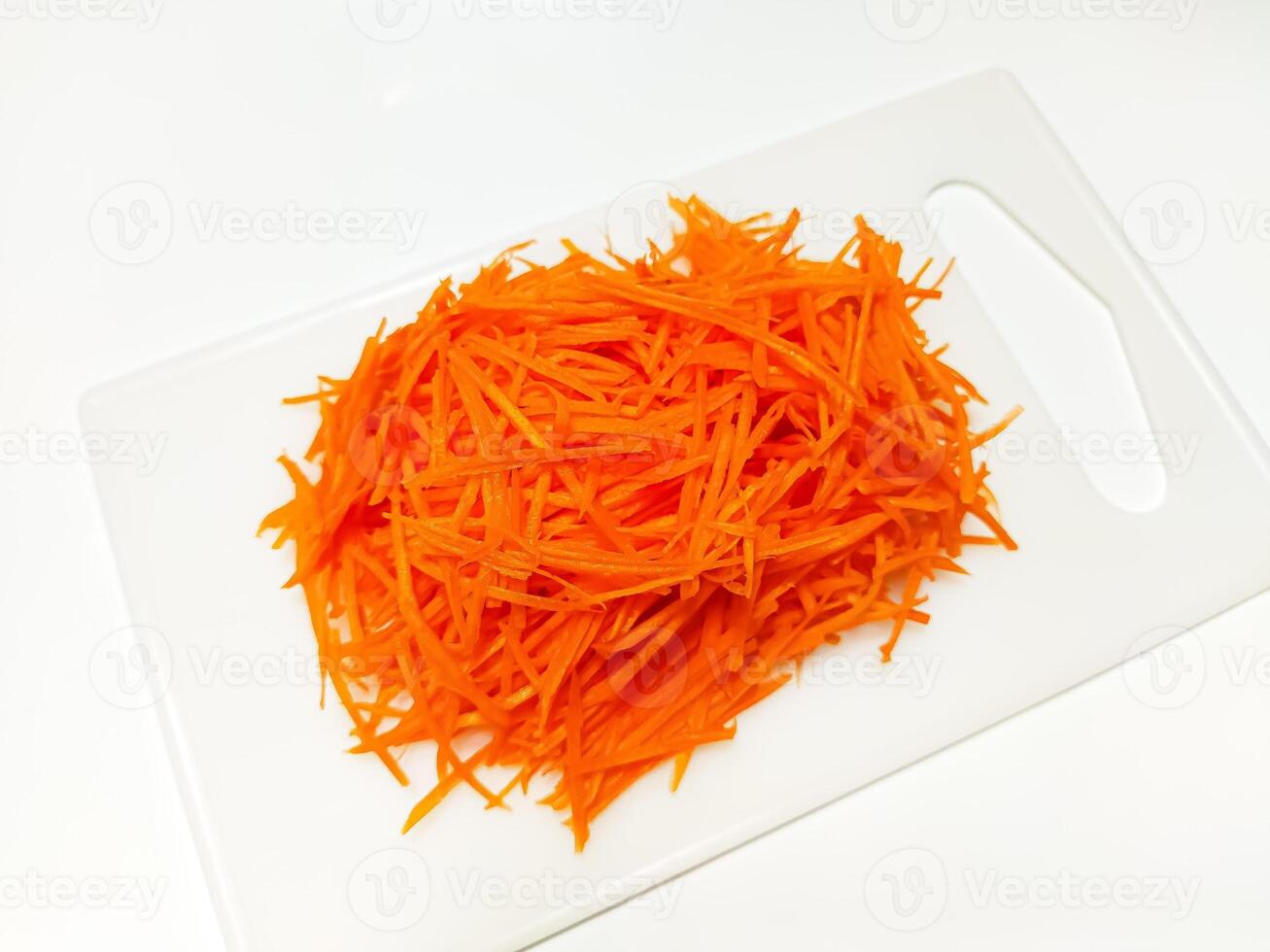 View of juice sliced carrots. Julienne carrot in a white plate. Copy space. photo