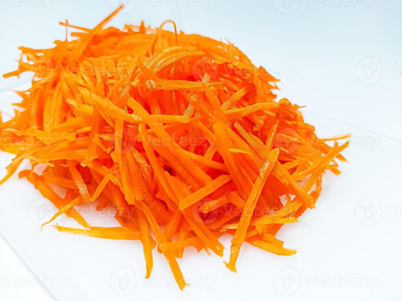 View of juice sliced carrots. Julienne carrot in a white plate. Copy space. photo