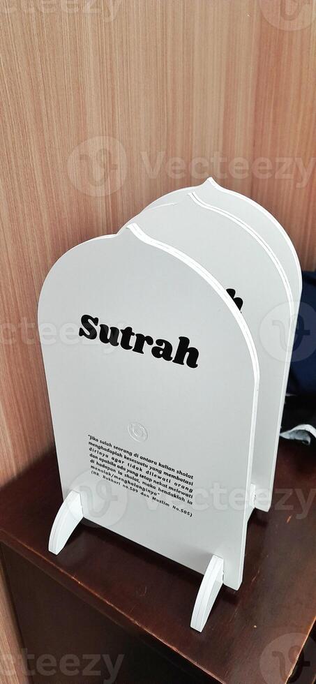 White board sutrah used for the barrier of people praying on the carpet of the mosque photo