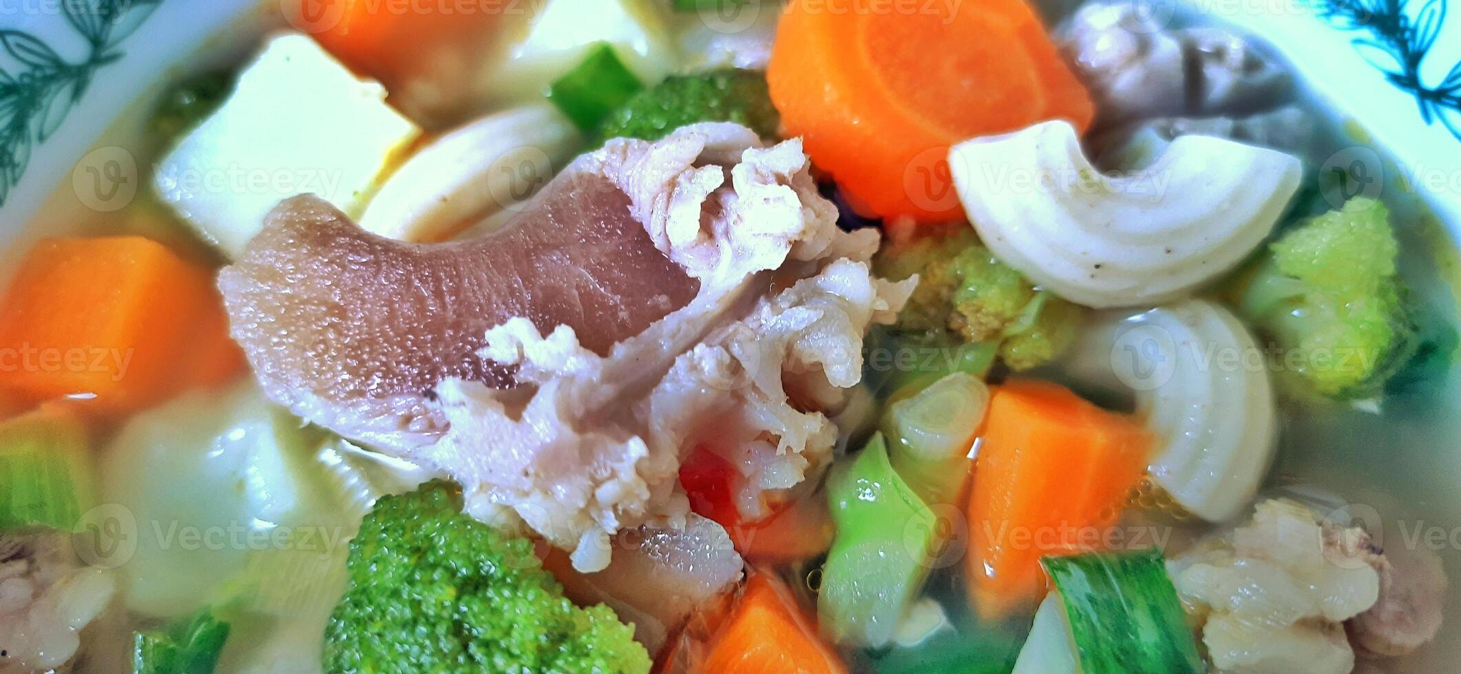 Sayur sop or vegetable with meat soup on the plate. Indonesian popular culinary. Healthy food and delicious photo